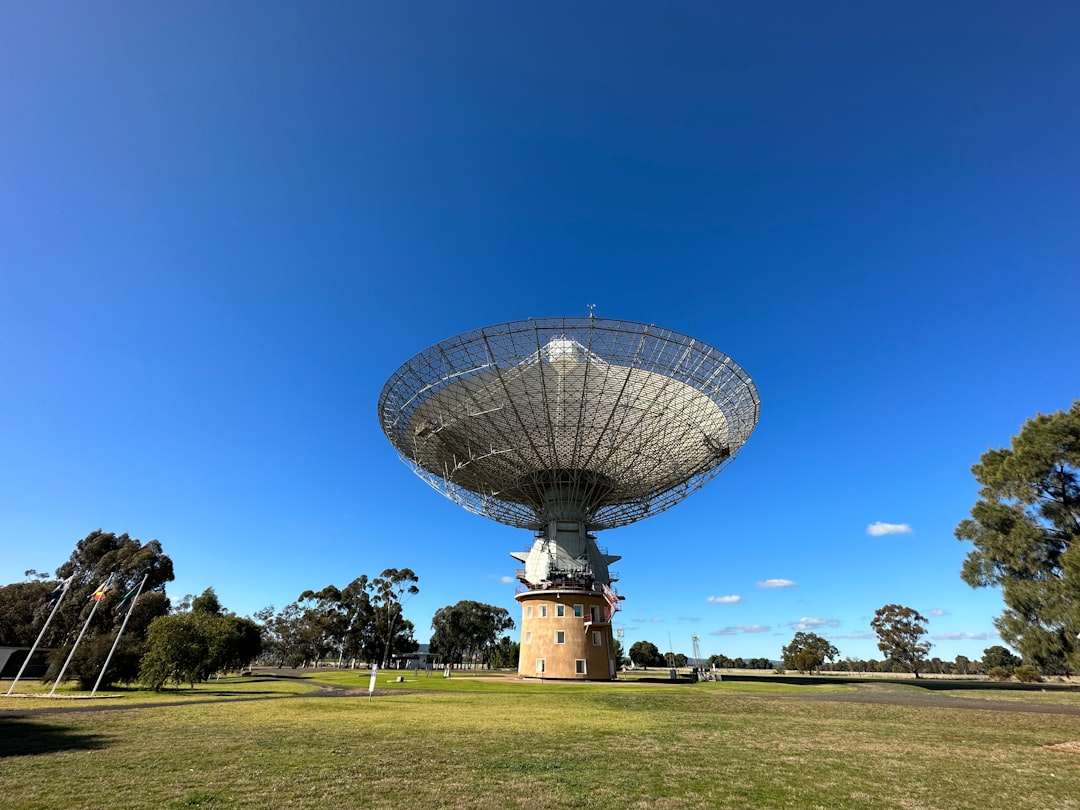 a large satellite dish sitting on top of a lush green field